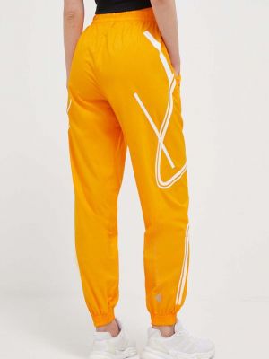 Kalhoty s potiskem Adidas By Stella Mccartney oranžové