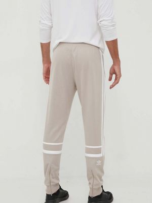 Sportovní kalhoty s aplikacemi Adidas Originals béžové