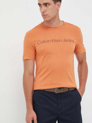 Koszulka bawełniana z nadrukiem Calvin Klein Jeans pomarańczowa