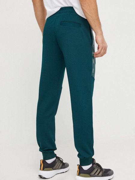 Sportovní kalhoty s aplikacemi Guess zelené