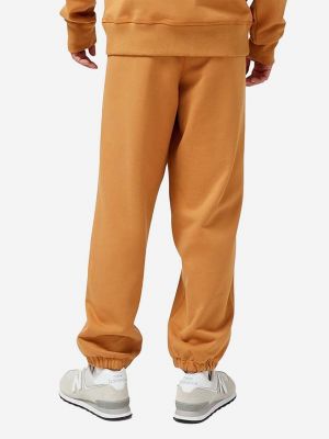 Bavlněné sportovní kalhoty New Balance oranžové
