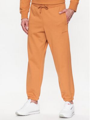 Sportovní kalhoty relaxed fit New Balance oranžové