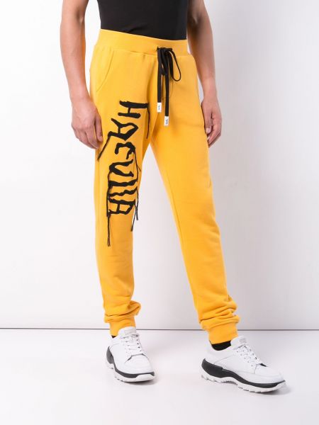 Sportovní kalhoty s výšivkou Haculla žluté