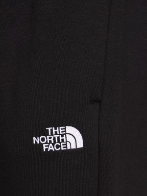Bavlnené teplákové nohavice The North Face čierna