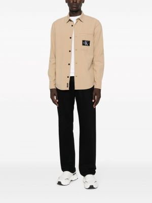 Medvilninė džinsiniai marškiniai Calvin Klein Jeans smėlinė