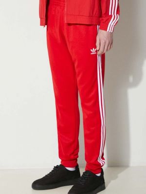 Slim fit sportovní kalhoty s aplikacemi Adidas Originals červené