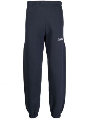 Bavlnené teplákové nohavice s výšivkou Late Checkout modrá