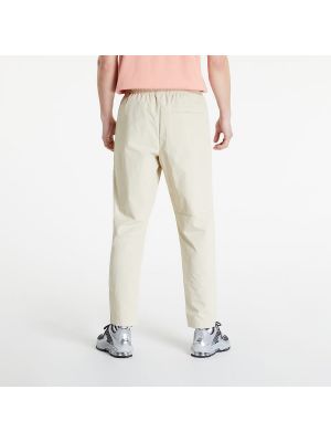 Pletené kalhoty Nike béžové