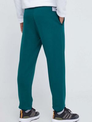 Bavlněné sportovní kalhoty s aplikacemi Adidas Originals zelené